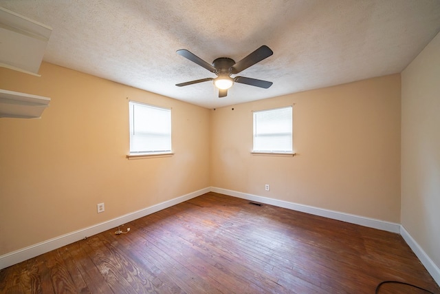 spare room featuring hardwood / wood-style flooring, a healthy amount of sunlight, and a textured ceiling