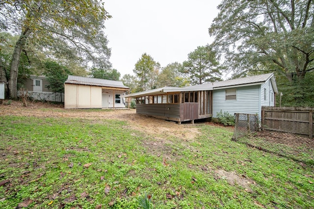 back of property featuring a shed and a yard