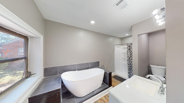 full bathroom with hardwood / wood-style flooring, vanity, separate shower and tub, and toilet