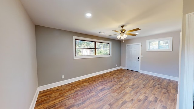 spare room with hardwood / wood-style flooring, ceiling fan, and a healthy amount of sunlight