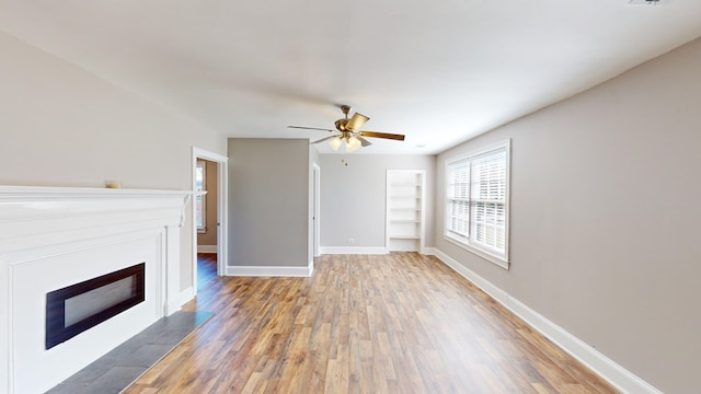 unfurnished living room with hardwood / wood-style floors and ceiling fan