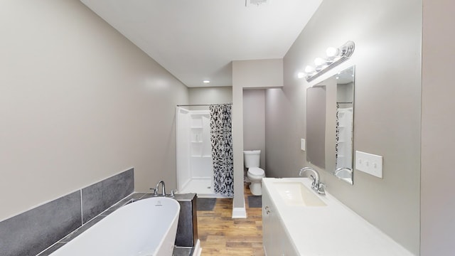 full bathroom with plus walk in shower, hardwood / wood-style floors, vanity, and toilet