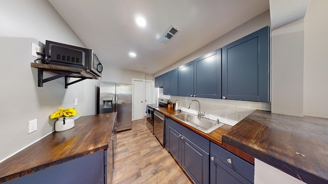 kitchen featuring blue cabinetry, sink, light hardwood / wood-style flooring, wooden counters, and appliances with stainless steel finishes