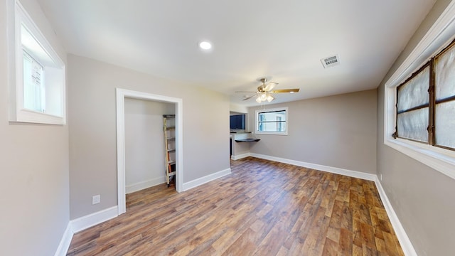 unfurnished living room with ceiling fan and dark wood-type flooring