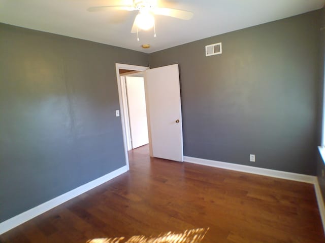 spare room with ceiling fan and dark hardwood / wood-style flooring