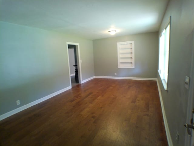 unfurnished room with dark hardwood / wood-style flooring