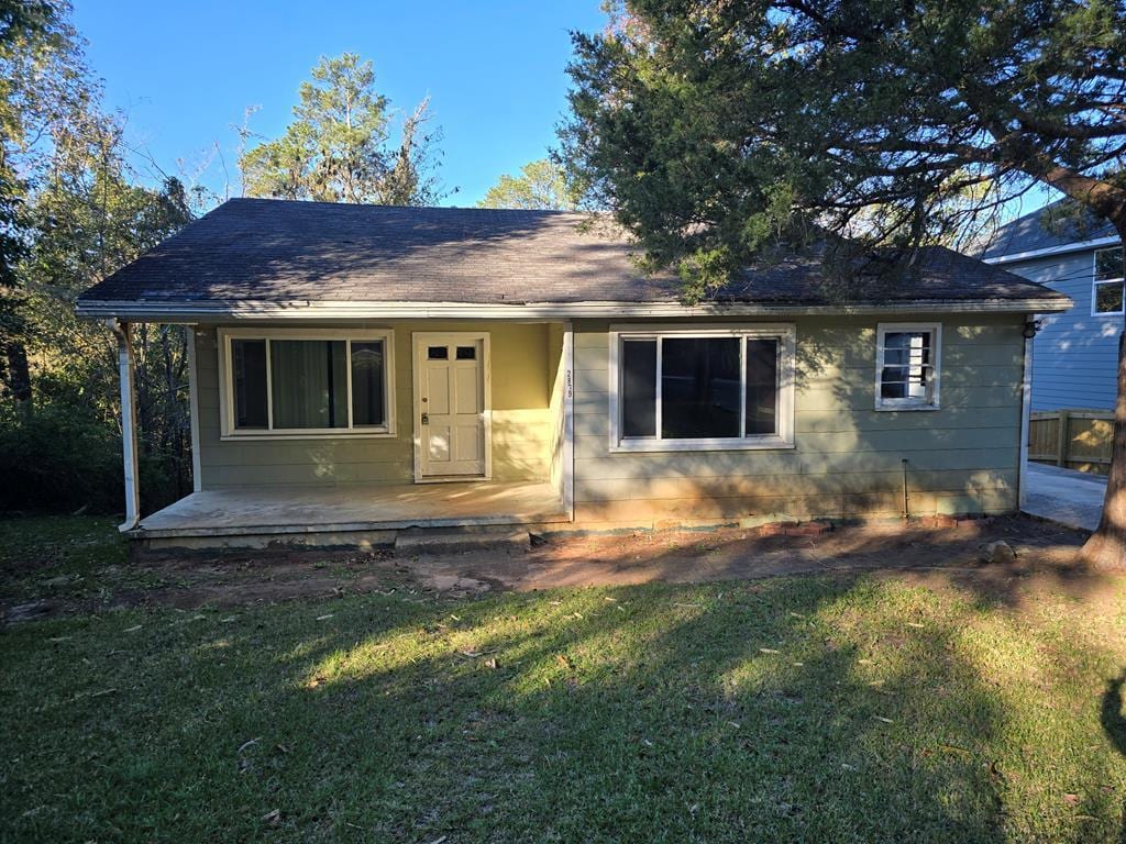 bungalow-style house featuring a patio area and a front lawn