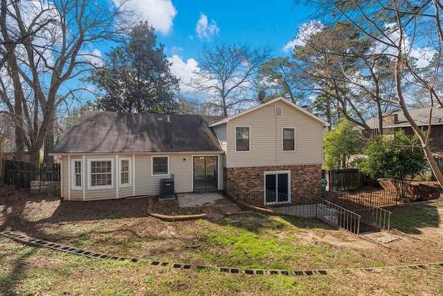 rear view of house with brick siding, central air condition unit, a patio area, and fence