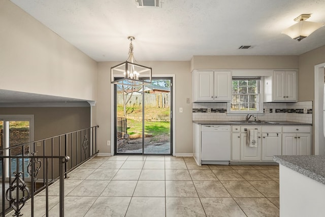 kitchen with dishwasher, white cabinets, backsplash, and a sink