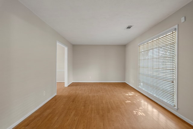 unfurnished room featuring visible vents, baseboards, and light wood-style floors