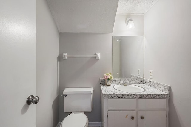 bathroom with toilet, a textured ceiling, and vanity