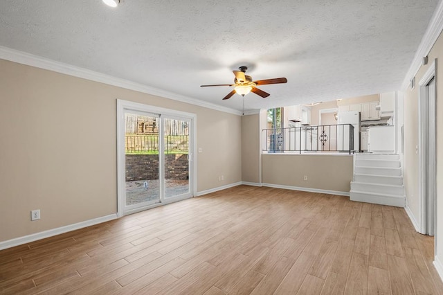 unfurnished room with ornamental molding, light wood-style flooring, plenty of natural light, and a textured ceiling