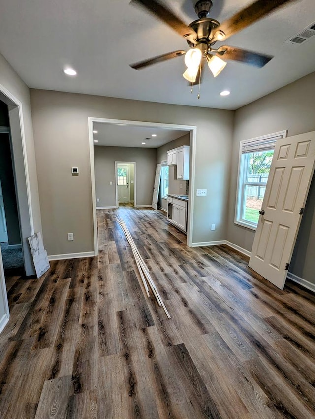 unfurnished living room with ceiling fan and dark hardwood / wood-style flooring