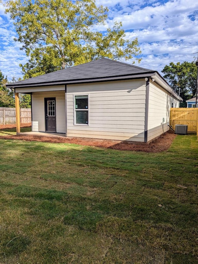 back of property featuring a lawn and central AC unit