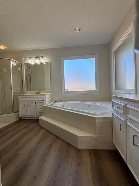 full bath with vanity, wood finished floors, a shower stall, and a bath