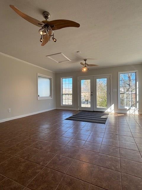 empty room with dark tile patterned floors, attic access, and baseboards