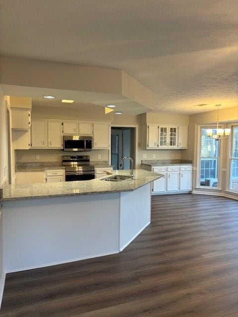 kitchen with stainless steel appliances, white cabinetry, a sink, and dark wood-type flooring