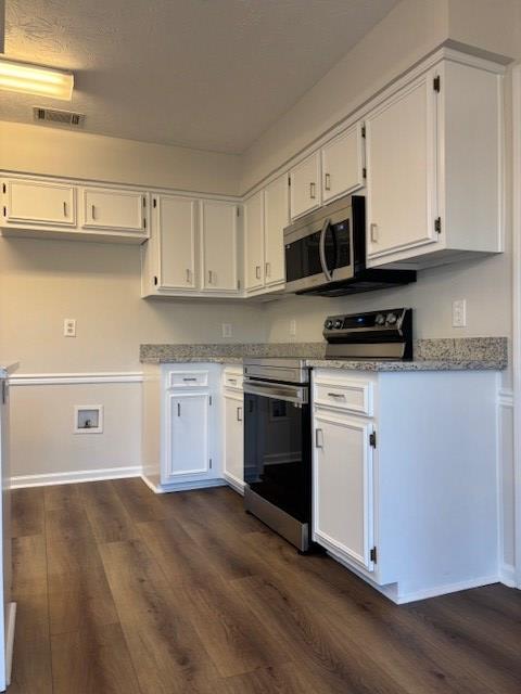 kitchen featuring white cabinetry, visible vents, stainless steel appliances, and dark wood finished floors