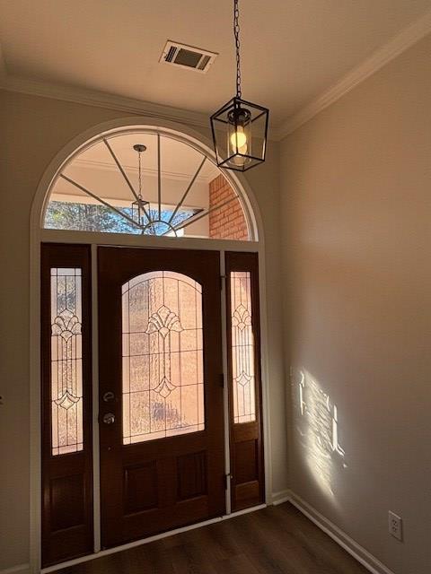 entryway with dark wood-style floors, a notable chandelier, visible vents, ornamental molding, and baseboards