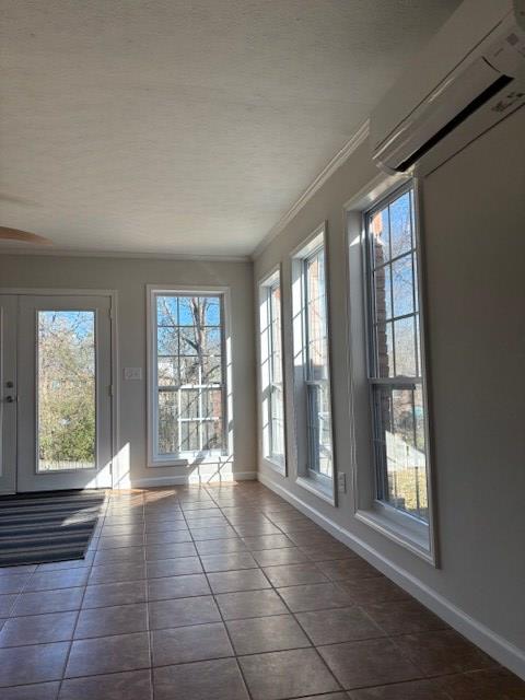 unfurnished sunroom featuring a wealth of natural light and a wall mounted AC