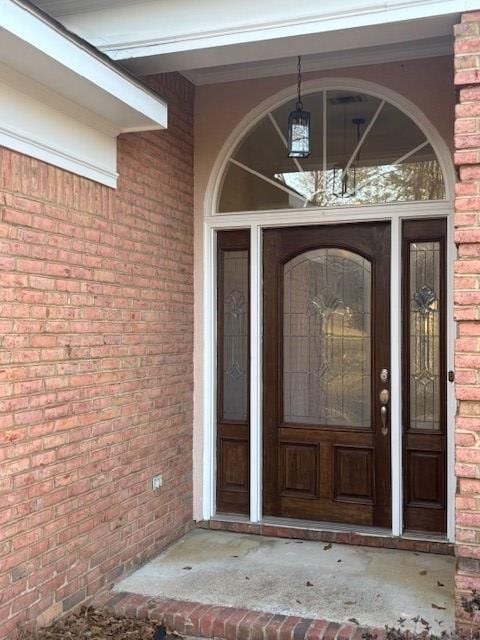 doorway to property with brick siding