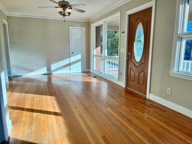 foyer with ceiling fan, ornamental molding, and light hardwood / wood-style flooring