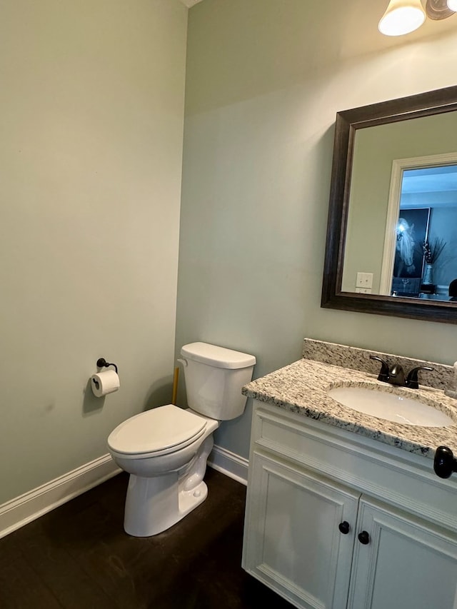 bathroom with hardwood / wood-style floors, vanity, and toilet