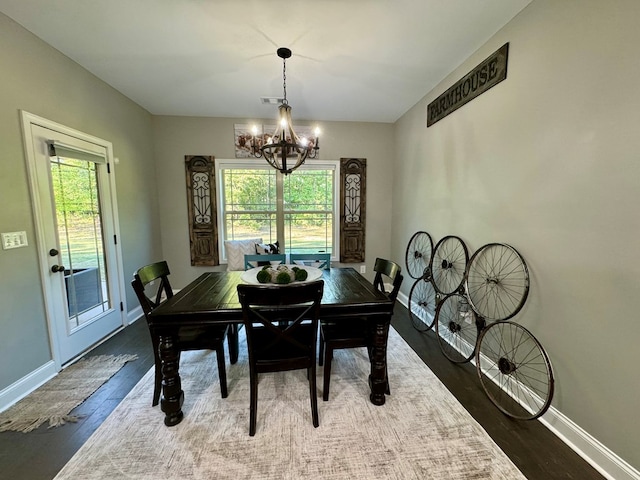 dining room with a chandelier, plenty of natural light, and dark wood-type flooring