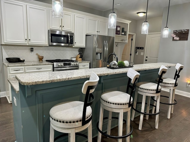 kitchen featuring a breakfast bar area, an island with sink, and appliances with stainless steel finishes