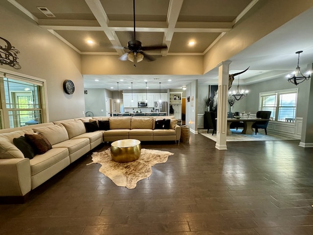 living room featuring beam ceiling, ornate columns, ceiling fan with notable chandelier, and coffered ceiling