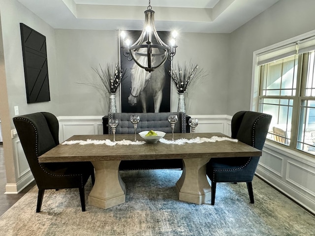 dining room with a raised ceiling and a notable chandelier