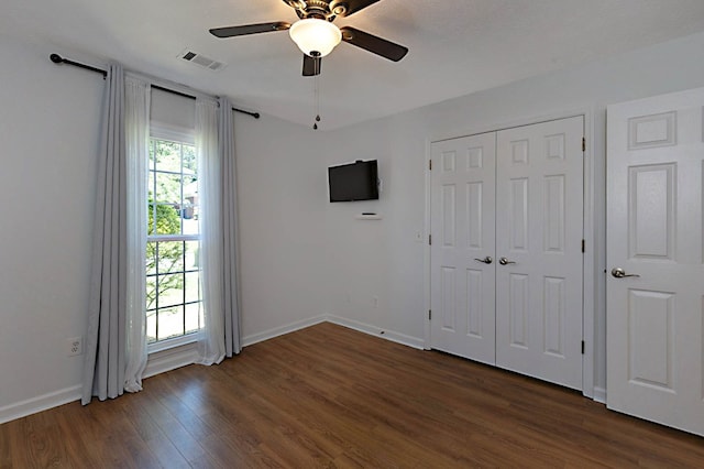 7191 Otter Dr, Midland, GA 31820 - unfurnished bedroom with dark wood-type flooring, baseboards, a ceiling fan, and a closet