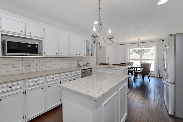 7191 Otter Dr, Midland, GA 31820 - kitchen featuring appliances with stainless steel finishes, a chandelier, a sink, a peninsula, and white cabinetry