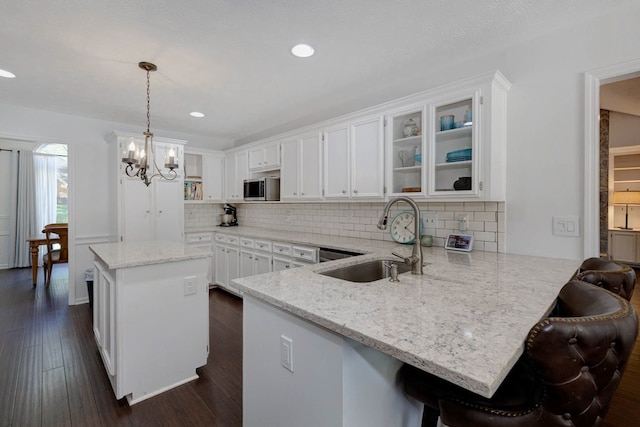 7191 Otter Dr, Midland, GA 31820 - kitchen featuring a sink, stainless steel microwave, a peninsula, white cabinets, and a kitchen island