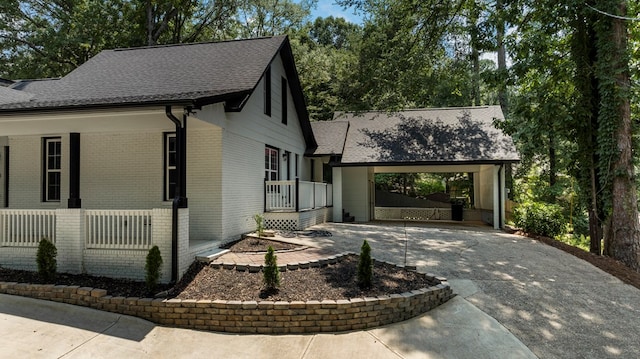 7209 Lullwater Rd, Columbus, GA 31904 - view of home's exterior with driveway, brick siding, a porch, and a shingled roof