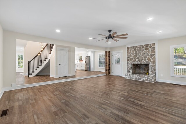 7209 Lullwater Rd, Columbus, GA 31904 - unfurnished living room featuring a ceiling fan, stairs, dark wood-style floors, a stone fireplace, and recessed lighting