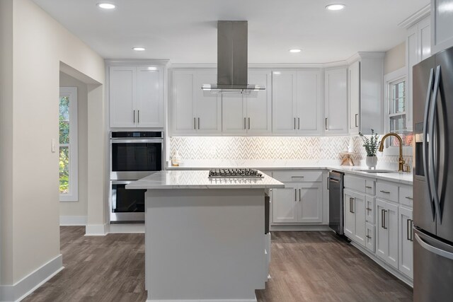 7209 Lullwater Rd, Columbus, GA 31904 - kitchen with island exhaust hood, stainless steel appliances, tasteful backsplash, a kitchen island, and recessed lighting