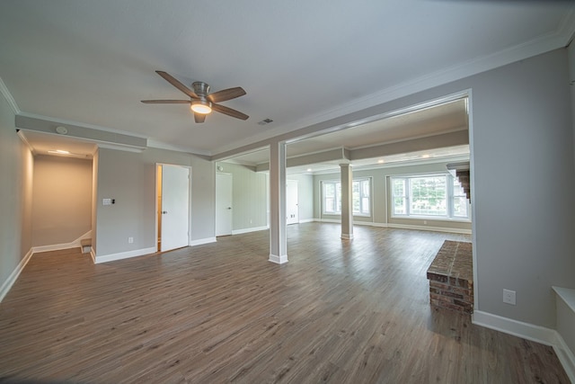 unfurnished living room featuring ornamental molding, a ceiling fan, ornate columns, wood finished floors, and baseboards
