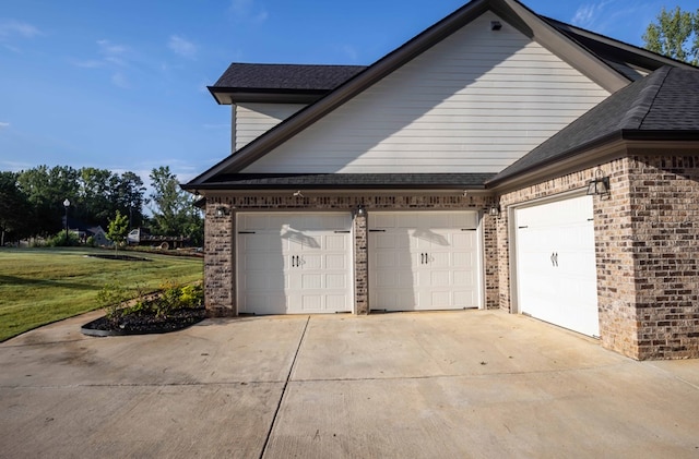 10312 Emerson Way, Midland, GA 31822 - view of property exterior with brick siding, an attached garage, driveway, a lawn, and a shingled roof