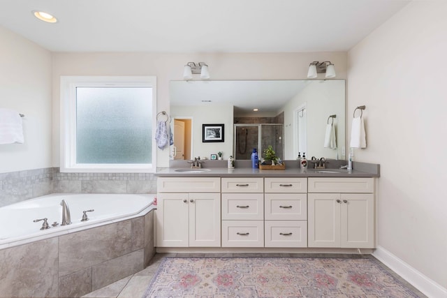 7514 Garrett Rd, Midland, GA 31820 - bathroom featuring double vanity, a shower stall, a garden tub, and tile patterned flooring