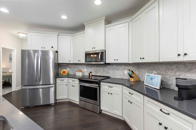 7514 Garrett Rd, Midland, GA 31820 - kitchen with appliances with stainless steel finishes, dark countertops, backsplash, dark wood-style flooring, and recessed lighting