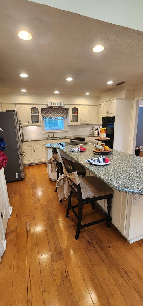 7400 Standing Boy Rd, Columbus, GA 31904 - kitchen featuring freestanding refrigerator, light wood finished floors, white cabinets, glass insert cabinets, and recessed lighting
