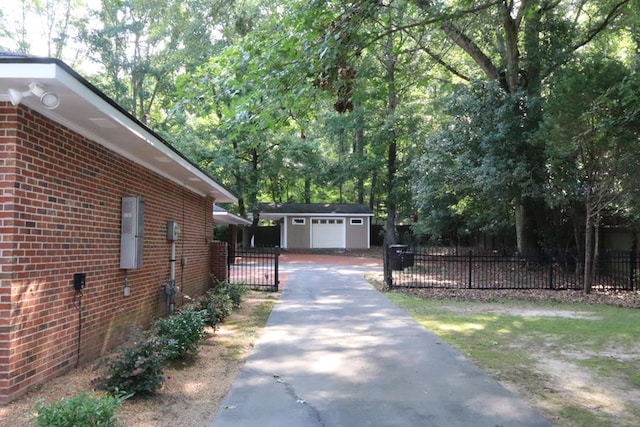 7400 Standing Boy Rd, Columbus, GA 31904 - view of side of property featuring asphalt driveway, brick siding, an outdoor structure, and a garage