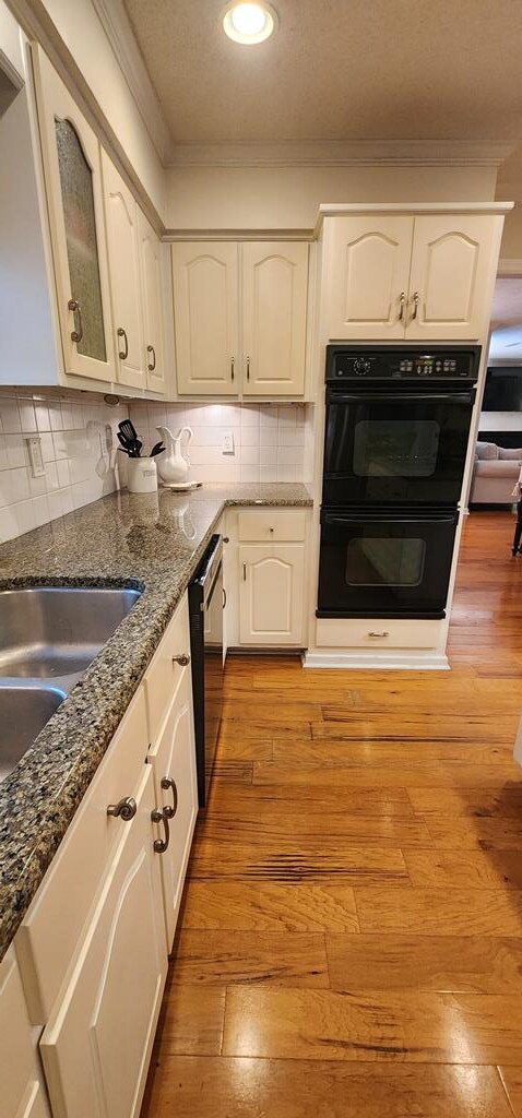 7400 Standing Boy Rd, Columbus, GA 31904 - kitchen with dishwasher, ornamental molding, white cabinets, dark stone countertops, and light wood-type flooring