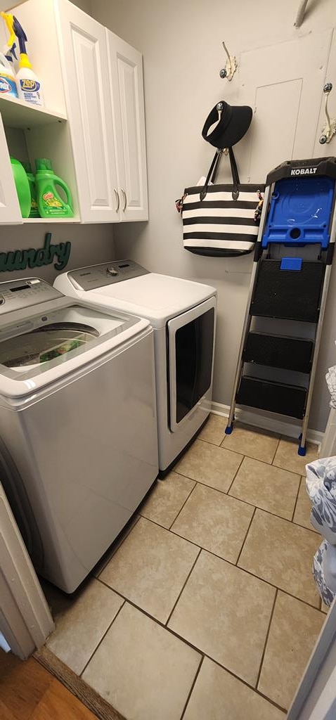 7400 Standing Boy Rd, Columbus, GA 31904 - laundry room featuring washing machine and clothes dryer, cabinet space, and light tile patterned flooring