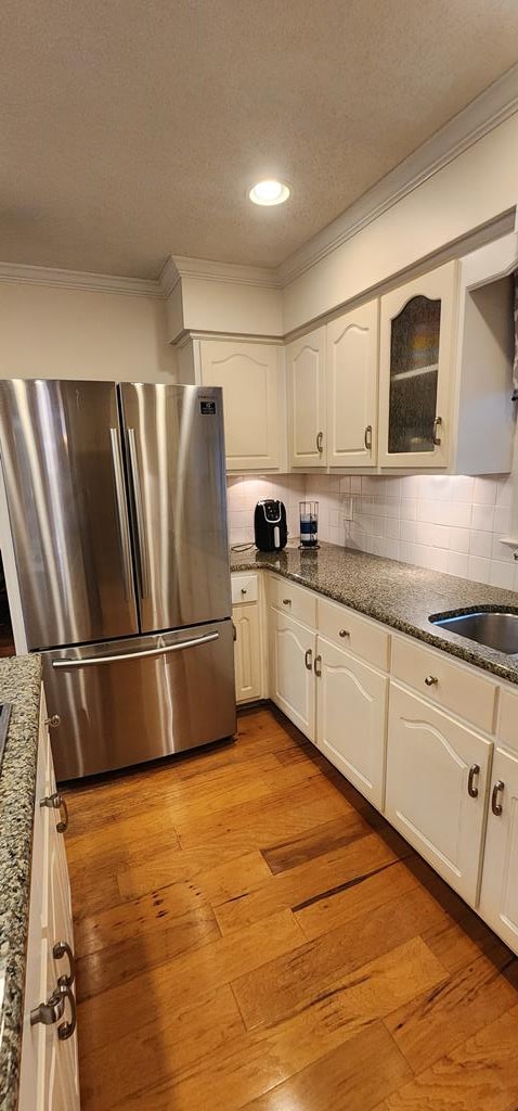 7400 Standing Boy Rd, Columbus, GA 31904 - kitchen featuring freestanding refrigerator, crown molding, white cabinetry, light wood-style floors, and dark stone countertops