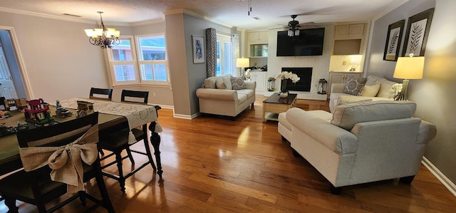7400 Standing Boy Rd, Columbus, GA 31904 - living area with ornamental molding, dark wood finished floors, a ceiling fan, a chandelier, and a large fireplace