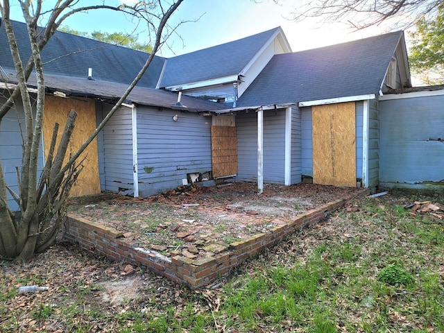 back of property with roof with shingles