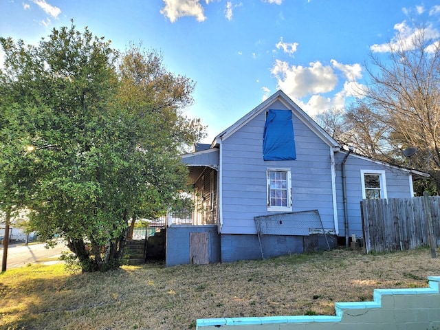 view of home's exterior featuring a yard and fence