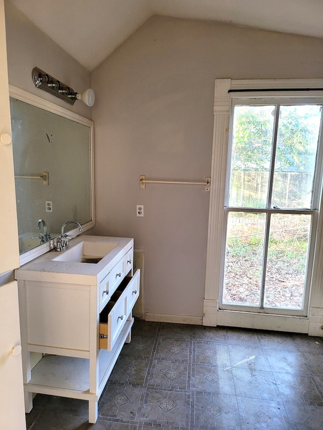 bathroom with vaulted ceiling and vanity